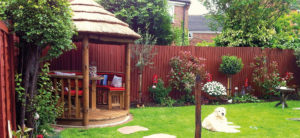 2 metre thatched gazebo in corner of small garden